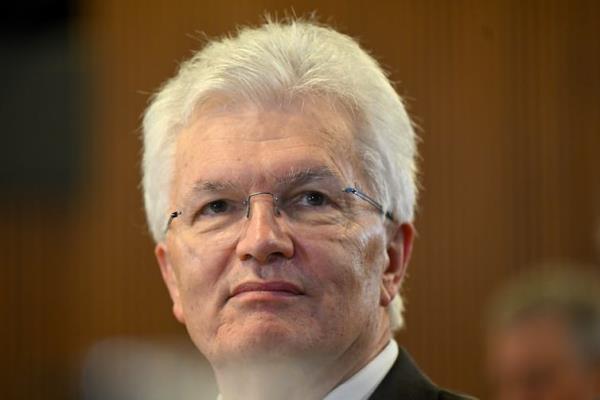 A man with white hair and glasses