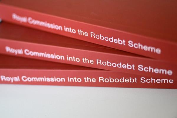 A close-up on three copies of the Royal Commission into the Robodebt Scheme